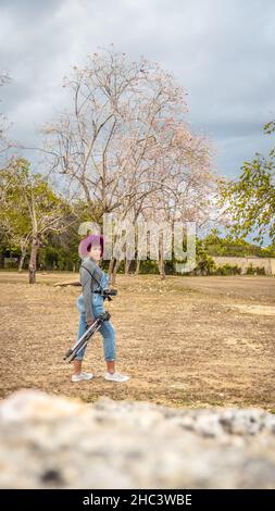 Ragazza che è dedicata alla fotografia si prepara da casa per andare a scattare foto di Foto Stock