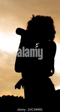 Ragazza che è dedicata alla fotografia si prepara da casa per andare a scattare foto di Foto Stock