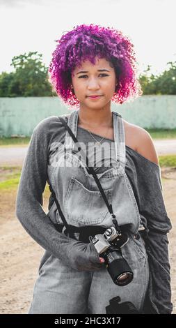 Ragazza che è dedicata alla fotografia si prepara da casa per andare a scattare foto di Foto Stock