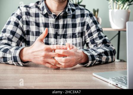 Un uomo che soffre di dolore articolare in mano e polso, artrite reumatoide e malattie professionali Foto Stock