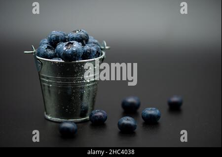 Primo piano di un mucchio di mirtilli freschi in un secchio piccolo. Foto Stock