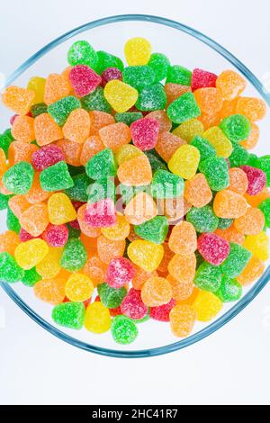 Caramelle di gelatina. Vista dall'alto delle caramelle gummy nella ciotola isolato su sfondo bianco foto storia verticale. Foto Stock