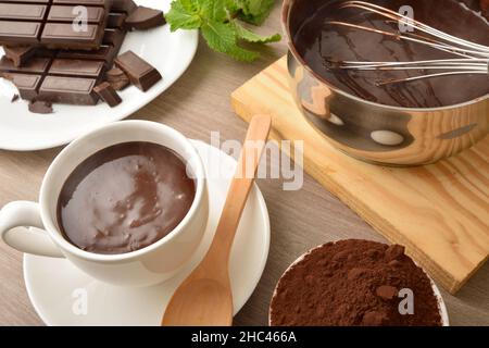 Tazza di cioccolata calda fatta in casa con ingredienti sul banco della cucina. Vista rialzata. Foto Stock