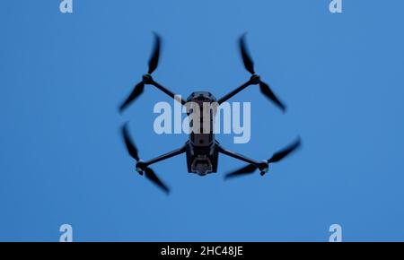 drone pieghevole che prende immagini aeree dal cielo blu ad alta quota Foto Stock