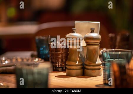 Primo piano di sale di pepe condimento Glinders di legno su tavola. Agitatori con sale e pepe su tavola di legno Foto Stock