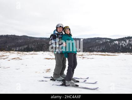 uomo e donna innamorati di sci su una pista di montagna innevata. Vacanze nella stazione sciistica di San Valentino. Gioia di rapporto. Una interessante vittoria attiva Foto Stock