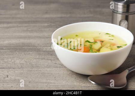 Zuppa di pollo su sfondo grigio testurizzato, vista dall'alto Foto Stock
