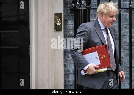 Il primo ministro britannico Boris Johnson con il suo cartellina rossa parte per PMQ's, Downing Street, Londra Foto Stock