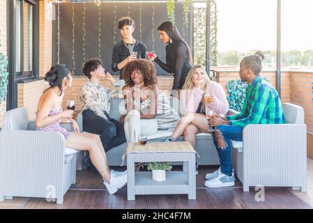 Amici multietnici che bevono in festa di giorno Foto Stock