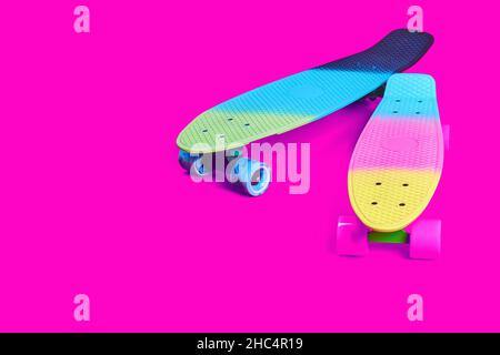 Due skateboard in plastica Rainbow Penny su sfondo cremisi Foto Stock