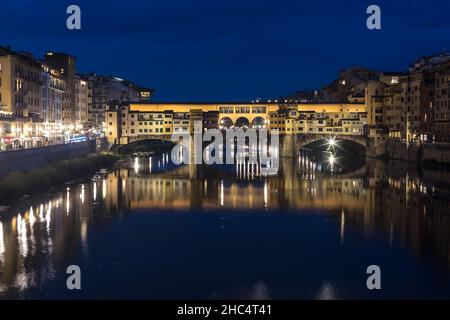 Ponte Vecchio si rifletteva sul fiume Arno con le prime luci notturne. Firenze Italia. Foto Stock