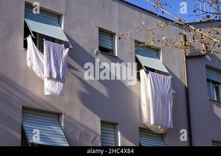 Vestiti, asciugamani e lenzuola appesi fuori dalla finestra per asciugare (Pesaro, Italia, Europa) Foto Stock