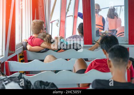 Vista posteriore dei passeggeri amanti della felicità che si abbraccia mentre si rilassano sul balcone godendo la vista dalla barca in mare. Felice coppia di turisti casual su t Foto Stock