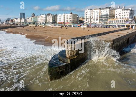 Onde che si infrangono su un frangiflutti di pietra sulla spiaggia di Brighton, East Sussex, Regno Unito. Foto Stock