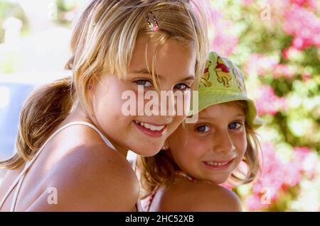 Ritratto delle due ragazze caucasiche felici che posano all'aperto Foto Stock