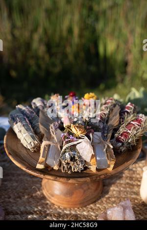 Colpo verticale di bastoni macchianti con fiori secchi su un vassoio di legno Foto Stock