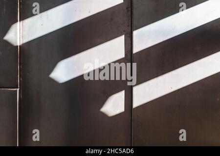 Scatto panoramico di una parete grigia e luci che appaiono come frecce su di essa Foto Stock