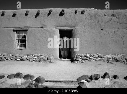 I visitatori esplorano le storiche strutture in adobe del 19th secolo presso il complesso storico vivente El Rancho de las Golondrinas vicino a Santa Fe, New Mexico. Foto Stock