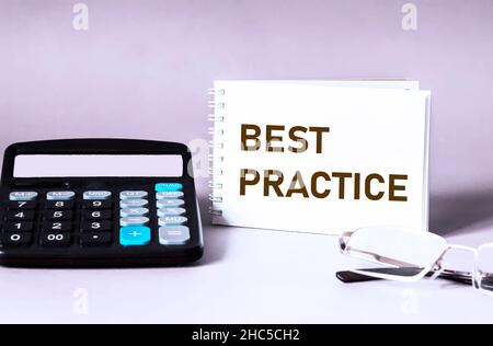 Best practice testo concetto su blocco note e sfondo chiaro con segni e calcolatrice Foto Stock