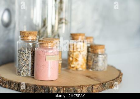 Varie forniture alimentari tra cui cereali, condimenti, salsa di pomodoro, olio in bottiglie di vetro e vasetti, pasta secca, prodotti in scatola su tavola da cucina Foto Stock