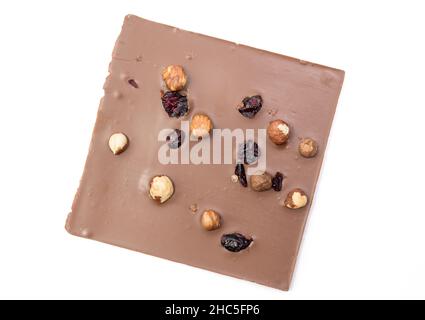 Cioccolato al latte artigianale con nocciole, uvetta e frutta secca su sfondo bianco. Tracciato di ritaglio incluso Foto Stock