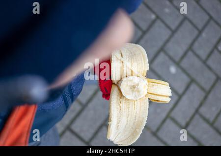 Vista dall'alto fuoco poco profondo di un uomo che mangia una banana Foto Stock