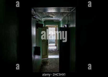 Corridoio oscuro e cupo in una vecchia casa abbandonata e porte aperte Foto Stock