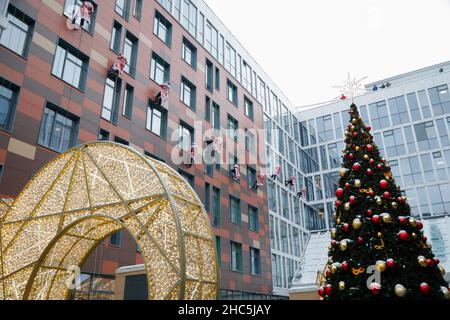 Mosca, Russia. 24th Dic 2021. Gli operatori di emergenza russi vestiti come Moroz di D scalano il muro di un ospedale per bambini mentre salutano i bambini per il prossimo anno nuovo a Mosca, Russia, il 24 dicembre 2021. Credit: Alexander Zemlianichenko Jr/Xinhua/Alamy Live News Foto Stock