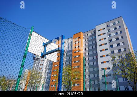 Angolo basso di una barriera di campo da basket vicino ad un alto edificio di appartamenti nel quartiere di stare Zegrze Foto Stock