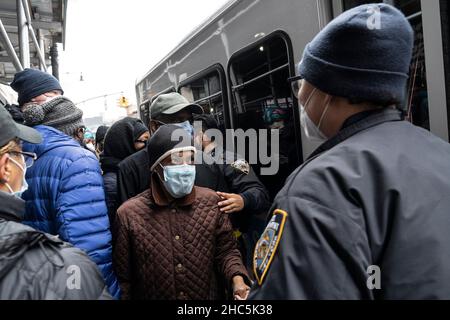 New York, Stati Uniti. 24th dicembre 2021. I newyorkesi si sforzano di ottenere gratuitamente i kit di test COVID-19 distribuiti dalla città alla luce della posizione in aumento nelle ultime settimane su un angolo di Church Avenue e Flatbush Avenue a Brooklyn. City ha annunciato la distribuzione di 2.000 kit in ciascuno dei cinque quartieri il 24 dicembre 2021. Una linea enorme di persone si è assemblata intorno al luogo di distribuzione per più di 5 isolati a Brooklyn. La distribuzione iniziò più tardi di quanto annunciato e una folla girò intorno al furgone dove venivano consegnate le divise. Credit: Pacific Press Media Production Corp./Alamy Live News Foto Stock