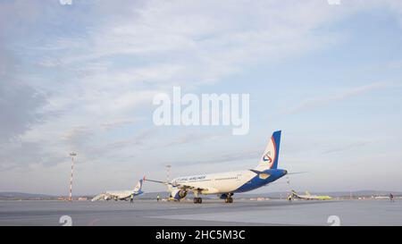 Code di alcuni aerei in aeroporto durante le operazioni di imbarco. Sono quattro aerei in una giornata di sole, con un cielo blu. Concetto di viaggio e trasporto Foto Stock