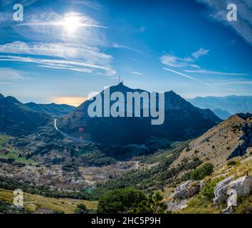 Vista dalla cima del Monte Lovcen al Mausoleo di Njego, guardando verso ovest e retroilluminata dal sole del tardo pomeriggio estivo. Foto Stock