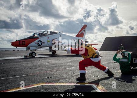 USA. 18th Dic 2021. Lt. CMdR. Rob Nelson, a sinistra, uno sparatutto assegnato alla portaerei USS George H.W. Bush (CVN 77), lancia un velivolo T-45C Goshawk assegnato all'Ala aerea di addestramento (TW) 1, 18 dicembre 2021. Il Capo della Naval Air Training sta conducendo un distacco di qualificazione del vettore a bordo di GHWB. Il distacco è la prima opportunità per gli aviatori navali studenti da addestramento Air Wings 1 e 2 di lanciare da e atterrare su un portaerei in mare, una fase mission-critical in sciopero di laurea e E2/C2 di addestramento pilota. GHWB fornisce all'autorità nazionale di comando flessibile e personalizzabile Foto Stock