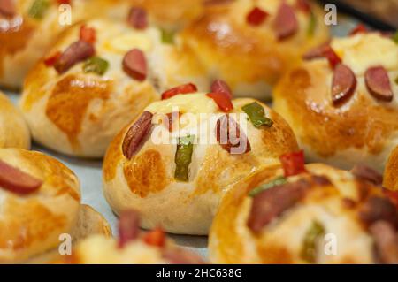 Deliziose mini pizze con salsicce, pepe, pomodoro e formaggio Foto Stock