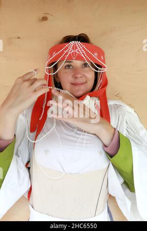 Donna che posa faccia in buca board del folk finlandese Foto Stock