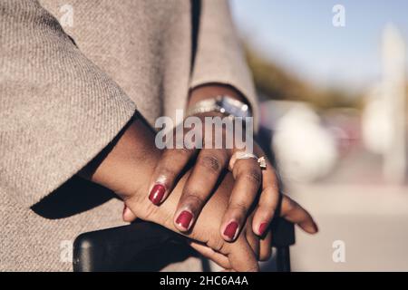 dettaglio delle mani di una donna d'affari nella valigia in attesa di un veicolo sulla strada Foto Stock