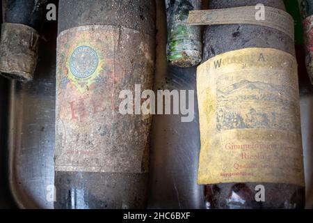 Neckargemuend, Germania - 11 settembre 2021: Bottiglie di vino molto vecchie con depositi da lunga cantina di stoccaggio come offerte in un mercato delle pulci Foto Stock