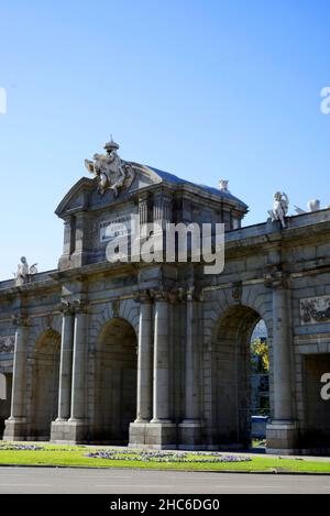 Lato bella vista della vecchia porta di Puerta de Alcala a Madrid, Spagna contro un cielo blu soleggiato Foto Stock