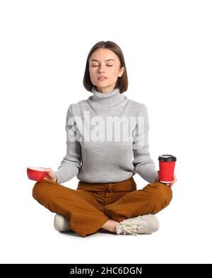 Donna meditante con tazze di caffè su sfondo bianco Foto Stock