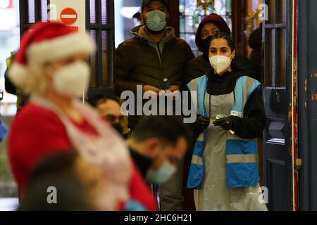 Le persone arrivano a ricevere un 'Jingle Jab' Covid vaccinazione richiamo iniezione al Redbridge Town Hall, a Ilford, Essex, come il programma di richiamo del coronavirus continua in tutto il Regno Unito il giorno di Natale.Foto data: Sabato 25 dicembre 2021. Foto Stock