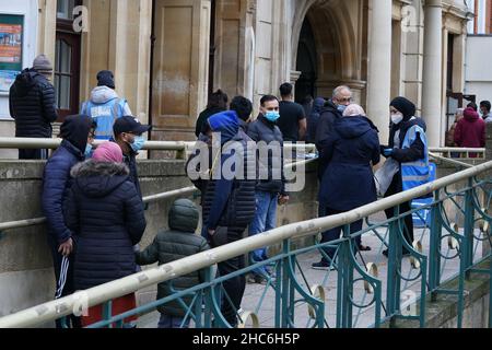 La gente arriva a ricevere un'iniezione di richiamo della vaccinazione 'Jingle Jab' di Covid al Municipio di Redbridge, ad Ilford, Essex, mentre il programma di richiamo del coronavirus continua in tutto il Regno Unito il giorno di Natale. Data foto: Sabato 25 dicembre 2021. Foto Stock