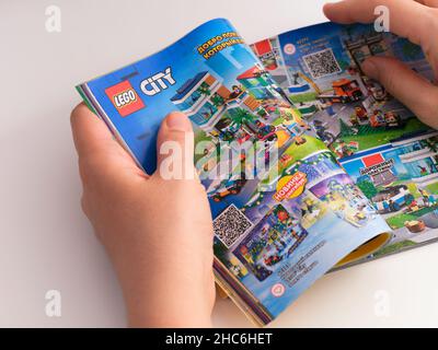 Tambov, Federazione russa - 21 dicembre 2021 Woman browsing Catalogo Lego su una pagina con Set Lego City. Foto Stock