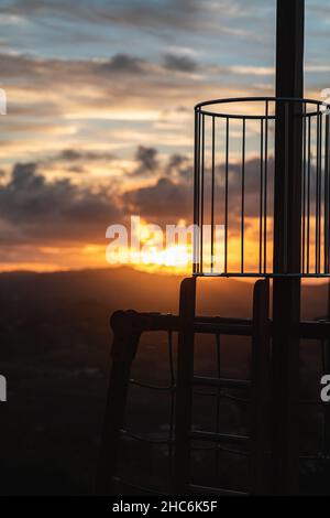 Messa a fuoco selettiva verticale delle costruzioni metalliche su sfondo colorato del tramonto Foto Stock