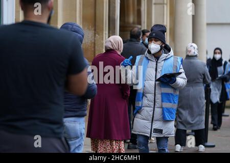 RITRASMISSIONE correzione data immagine a Sabato 25 dicembre, 2021 persone arrivano a ricevere un 'Jingle Jab' Covid vaccinazione richiamo iniezione al Redbridge Town Hall, a Ilford, Essex, come il programma di richiamo del coronavirus continua in tutto il Regno Unito il giorno di Natale. Data foto: Sabato 25 dicembre 2021. Foto Stock