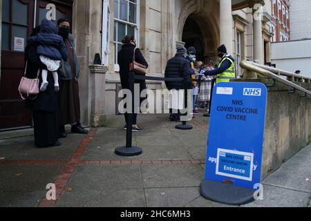 RITRASMISSIONE correzione data immagine a Sabato 25 dicembre, 2021 persone arrivano a ricevere un 'Jingle Jab' Covid vaccinazione richiamo iniezione al Redbridge Town Hall, a Ilford, Essex, come il programma di richiamo del coronavirus continua in tutto il Regno Unito il giorno di Natale. Data foto: Sabato 25 dicembre 2021. Foto Stock