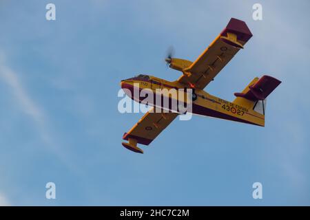 Inquadratura a basso angolo del Canadair Fire Fight Airplane che vola contro il cielo blu Foto Stock