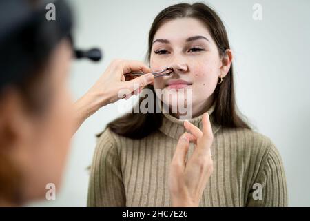 Dottore professionale di otorhinolaringologist che fa esame del naso con otoscopio in ospedale moderno. Congestione nasale, sinusite, allergia concetto Foto Stock
