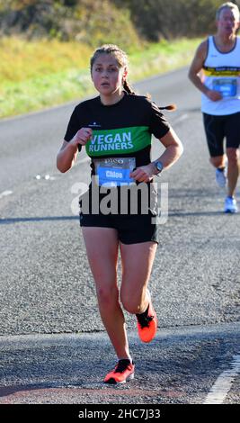 Giovane donna Mezza maratona runner in corsa su strada. Foto Stock