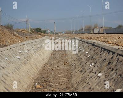 canale di drenaggio dell'acqua sul lato della strada come luogo per lo smaltimento dell'acqua dall'autostrada al fiume Foto Stock