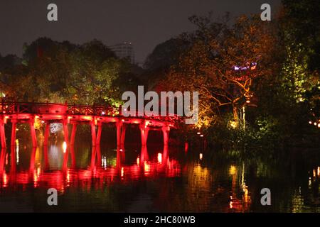 Il legno dipinto di rosso il Ponte di Huc nel quartiere vecchio di Hanoi di notte Foto Stock